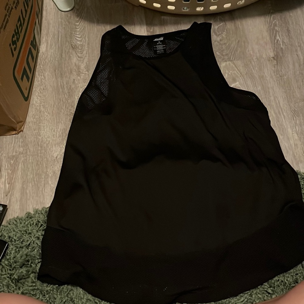 Black athletic tank top with mesh around the arms and at the bottom